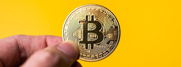 bitcoin w dłoni mężczyzny