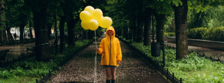 Osoba z balonami w deszczu